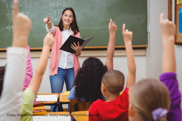 Lehrerin an der Tafel vor einer Klasse